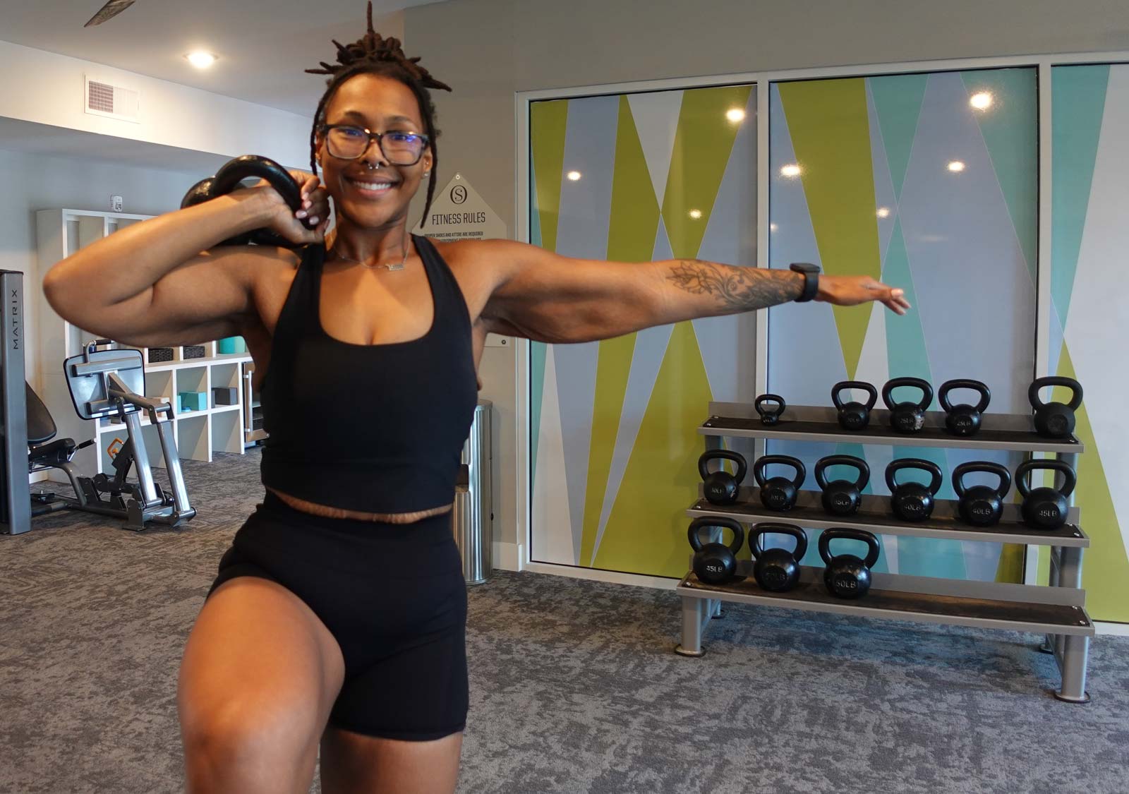 A coach exercises while smiling at the camera.