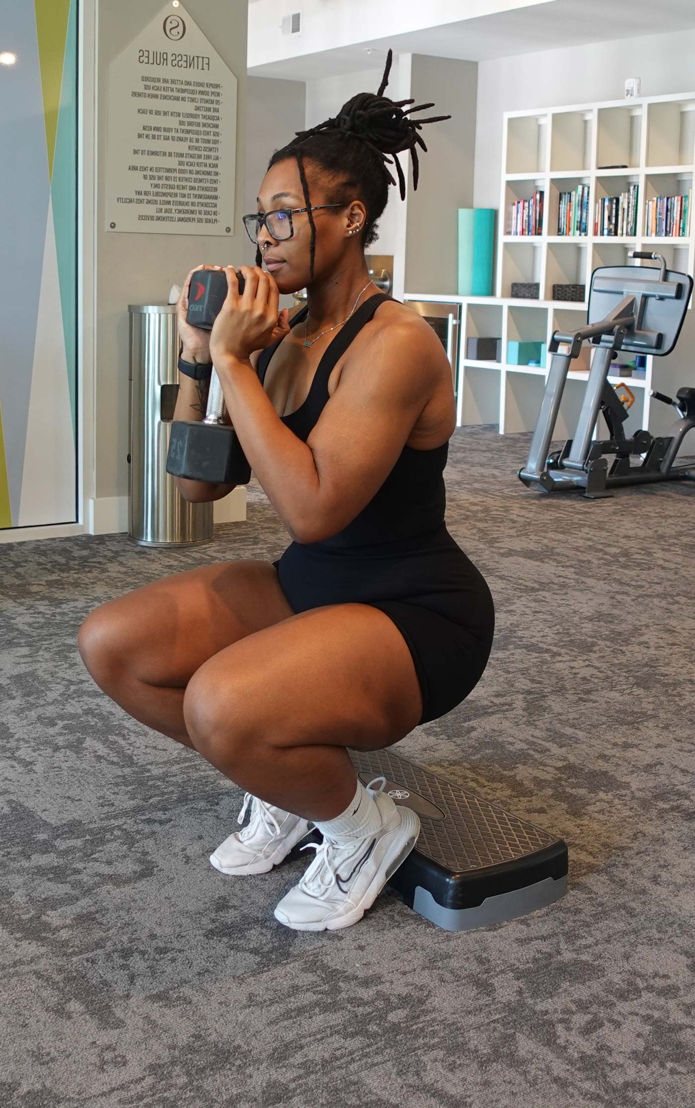 A coach performing a workout in black gym wear.